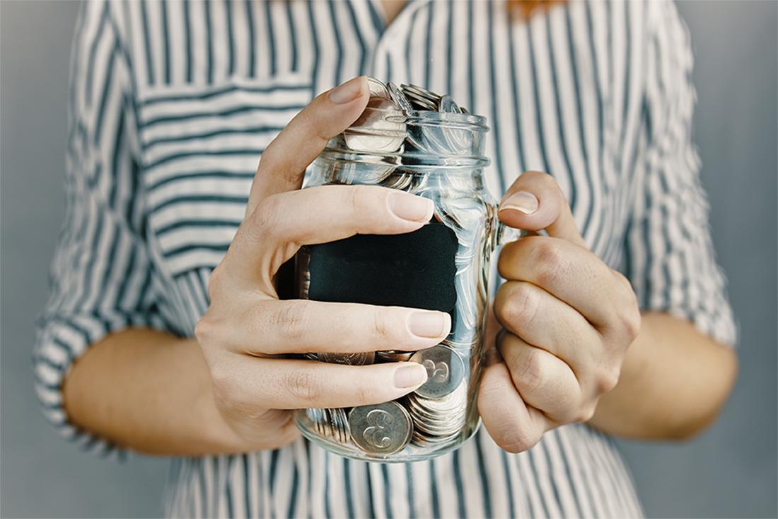 Image of a person holding a jar of coins